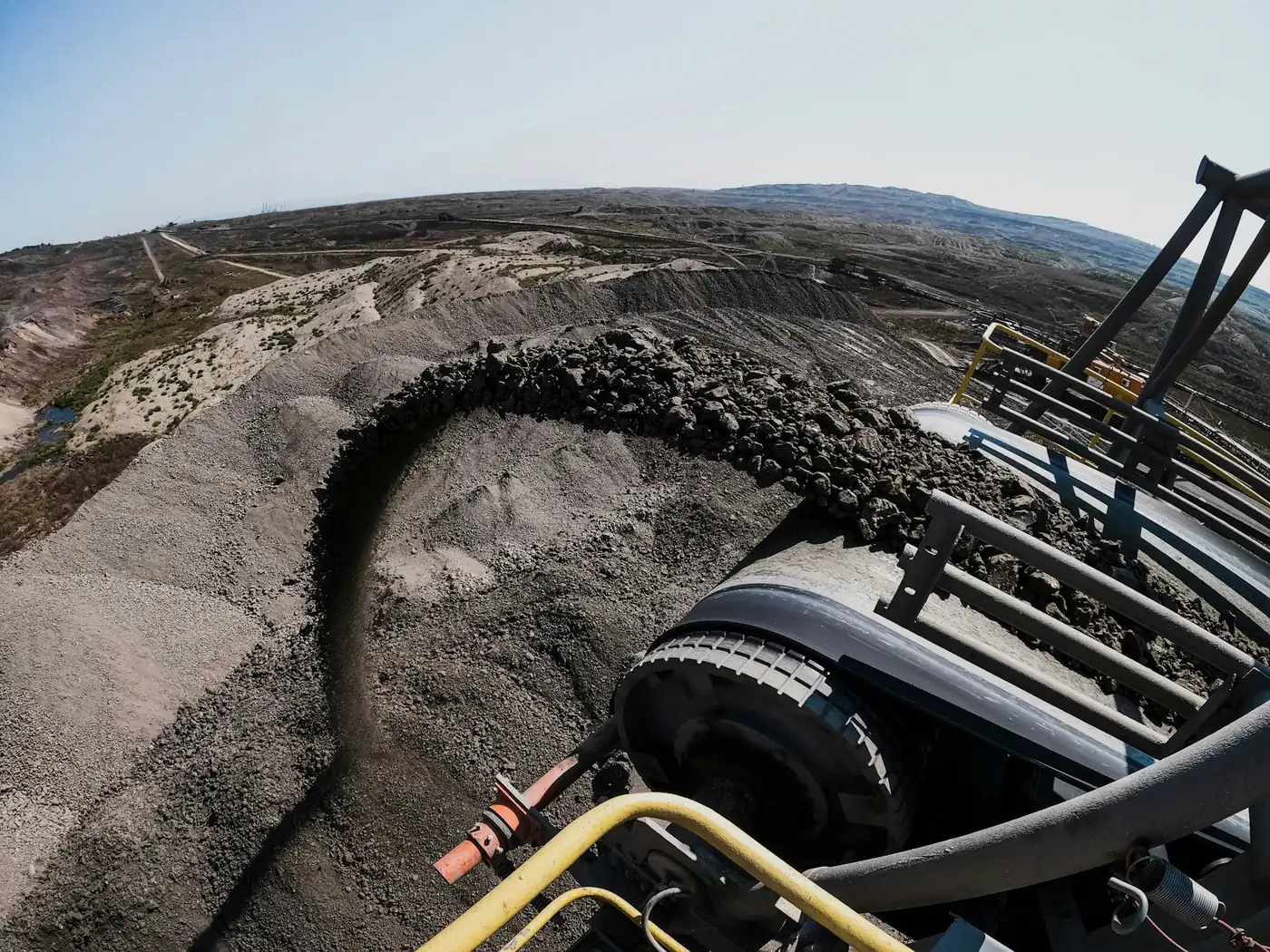 Crushed basalt stockpiles and conveyor at the quarry